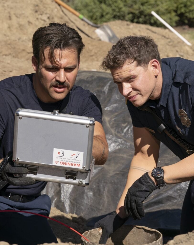 Buck and Eddie look at something together during 9-1-1 Season 8 Episode 6.