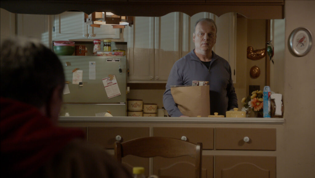 Sid at home with a bag of groceries on Blue Bloods Season 14 Episode 15.