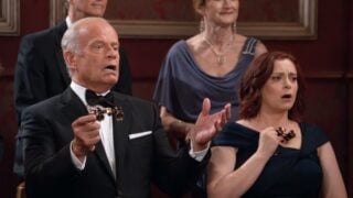 Frasier and Phoebe hold opera glasses and gasp